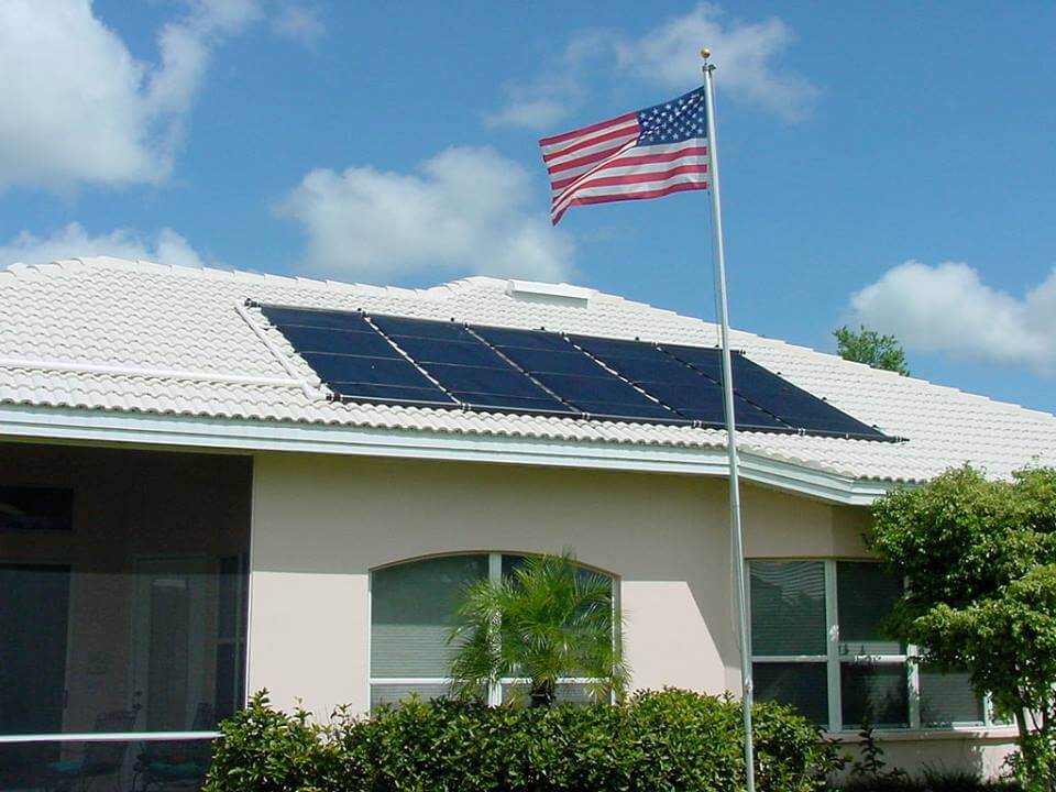 solar pool heating panel on roof next to American flag